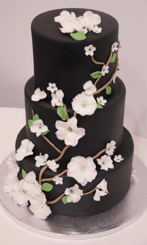 Layer cake noir avec branches de fleur sculptées en sucre