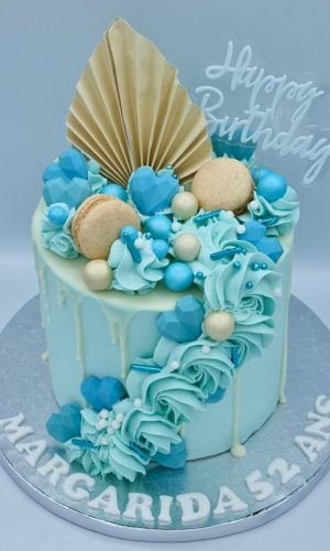 Layer cake bleu bohème avec macarons et pochage